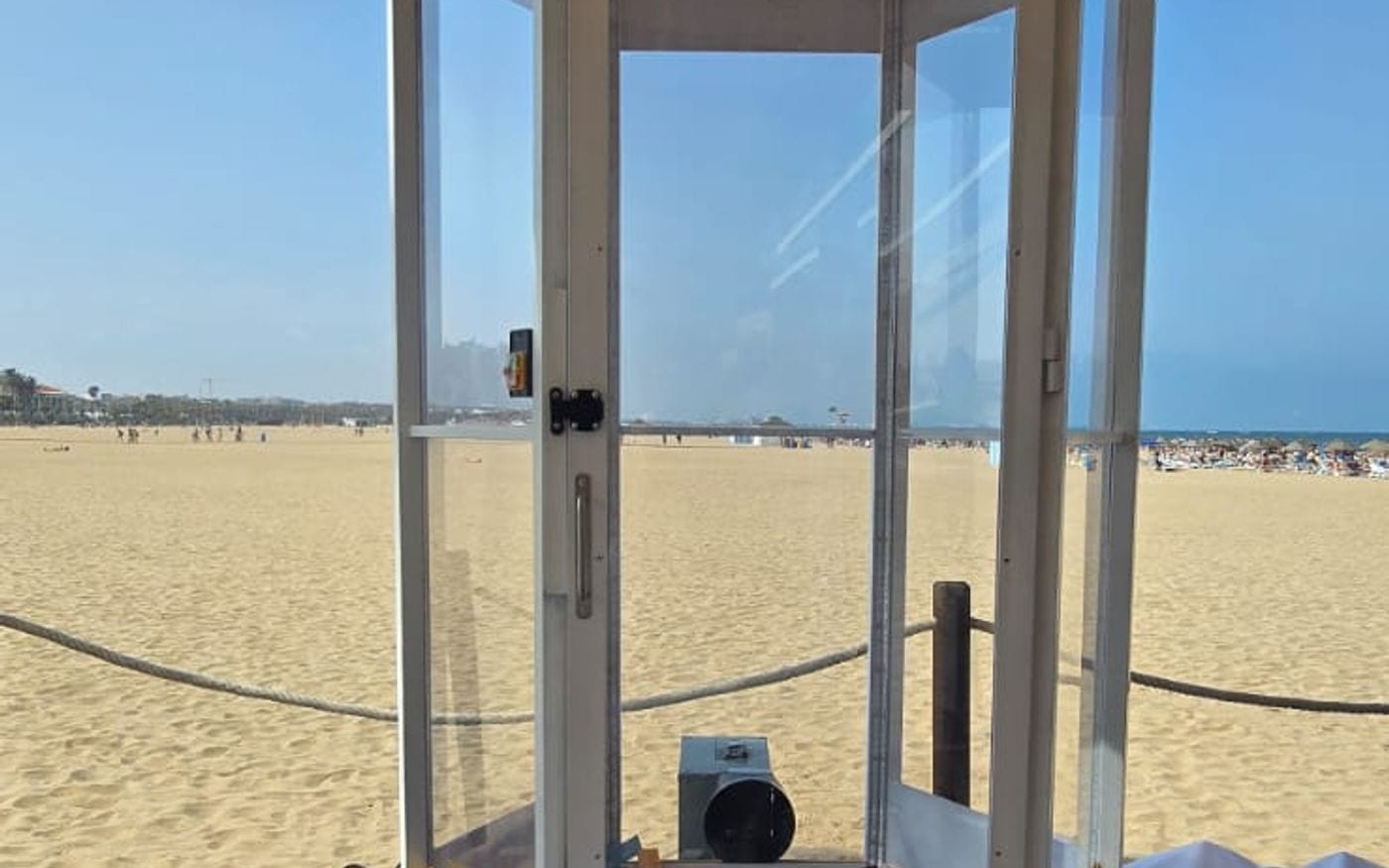 Cabina de viento montada sobre tarima en un evento en la playa
