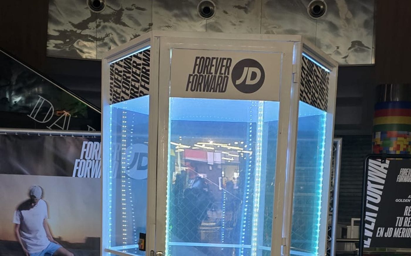 Cabina de viento con iluminación azul montada dentro de una tienda de ropa deportiva